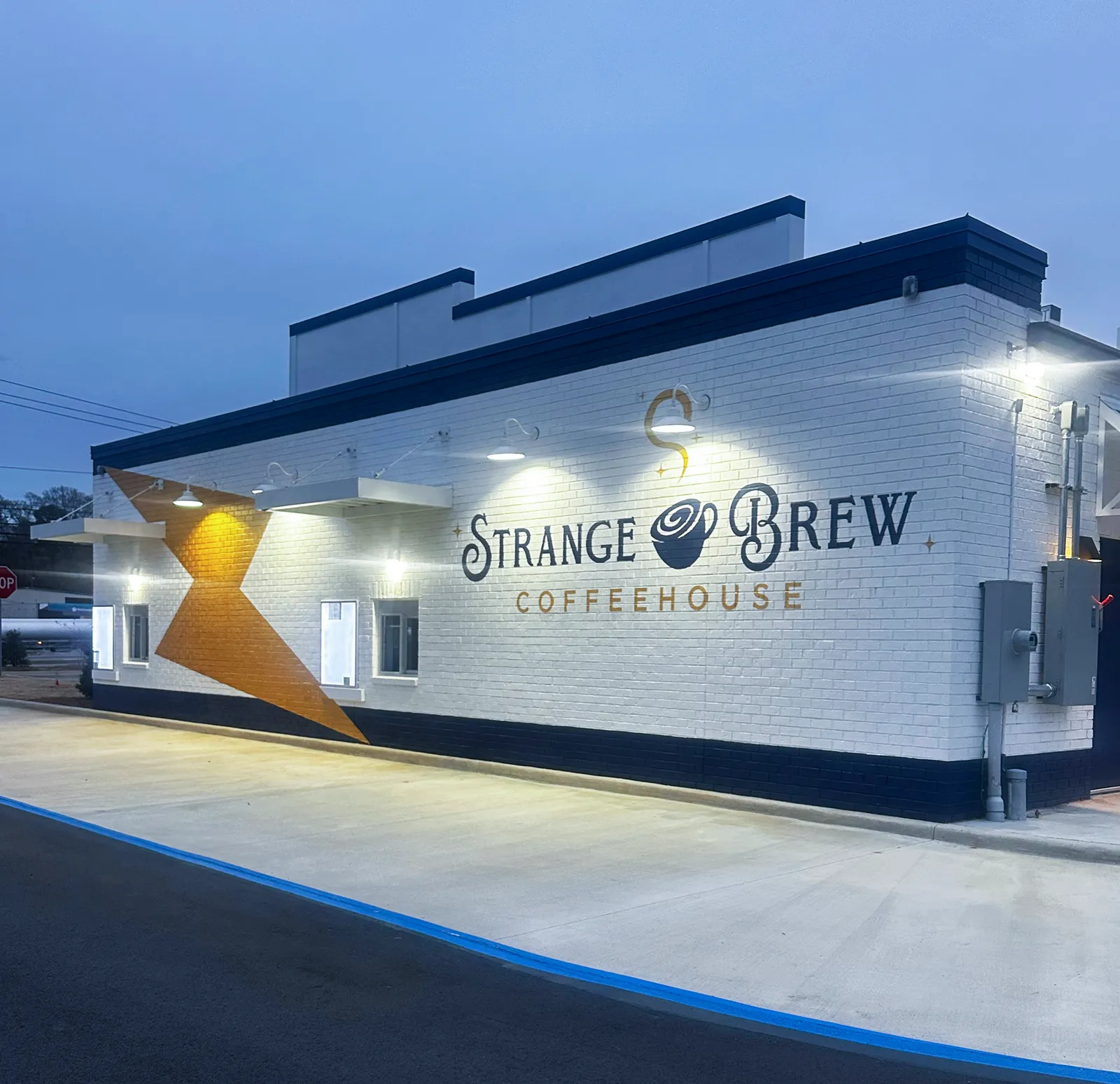 Strange Brew Coffeehouse building with gold super graphics at dusk, Northport AL
