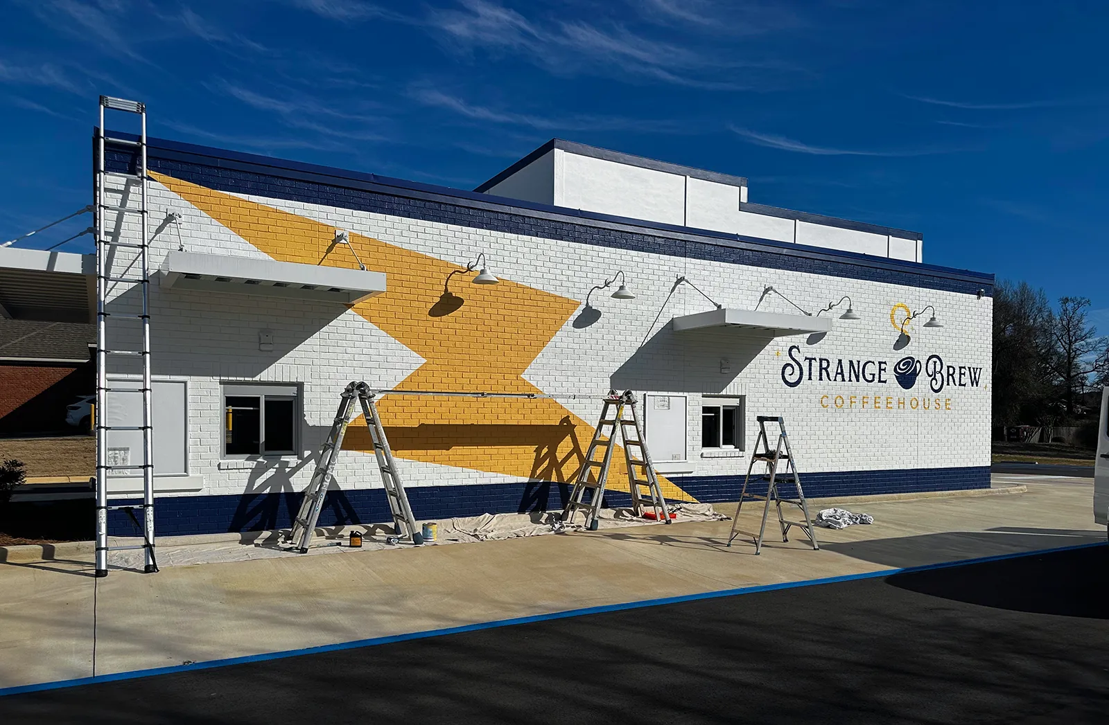 Large-scale hand-painted gold super graphics on the Strange Brew Coffeehouse building, Northport