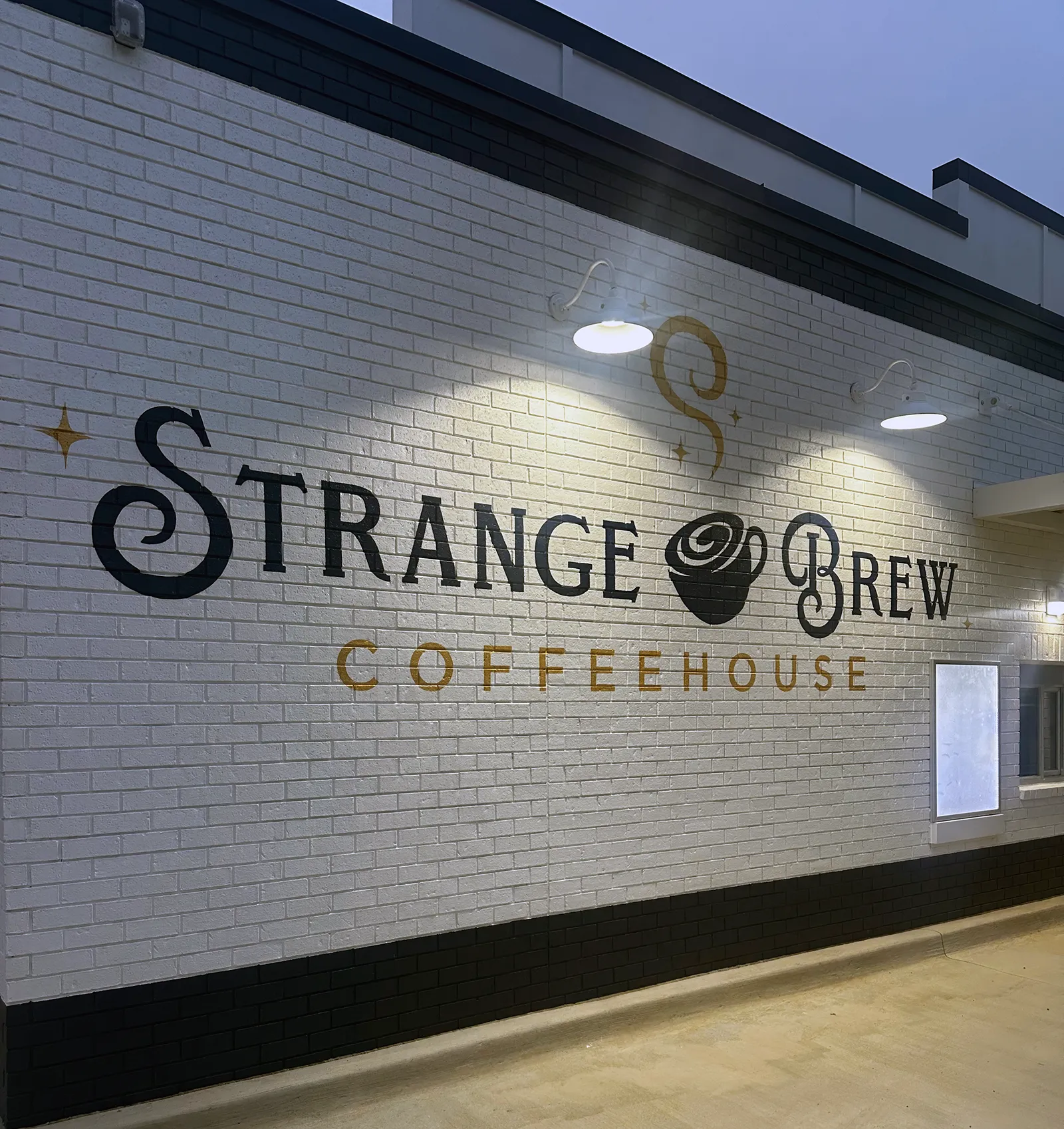 Strange Brew Coffeehouse hand-painted wall sign lit at night, Northport AL
