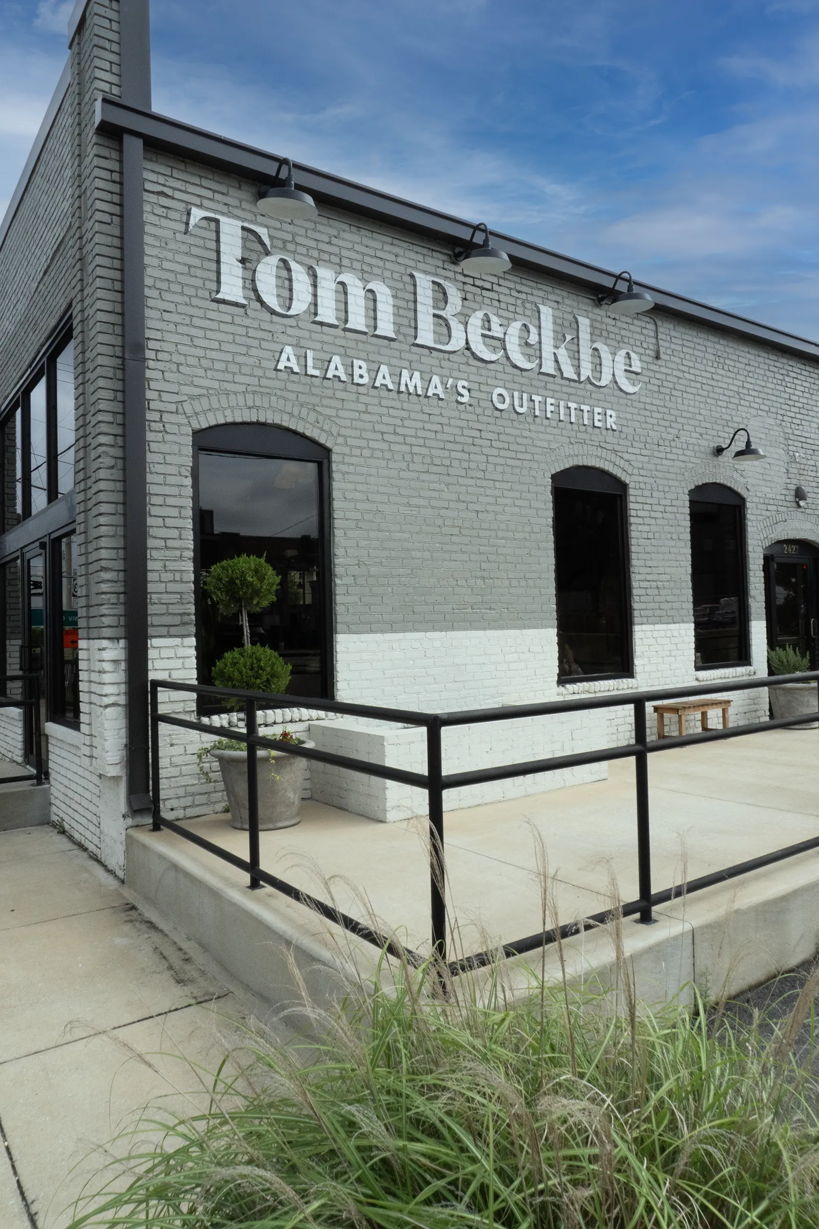 Hand-painted Tom Beckbe Alabama's Outfitter lettering on brick in Tuscaloosa